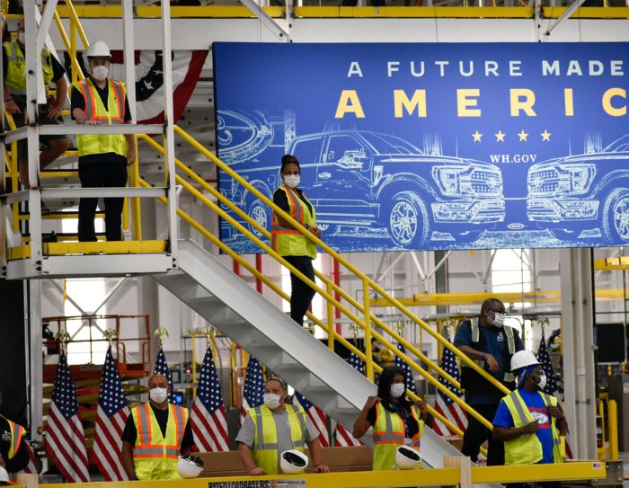 Workers at the Ford Motor Co. Rouge Electric Vehicle Center in Dearborn watch President Joe Biden deliver remarks on the electric F-150 Lightning pickup truck, which will be produced at the factory, and his American Jobs Plan.