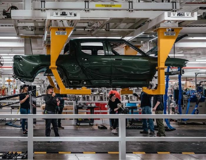 Workers assemble components of a Rivian electric vehicle at the company's manufacturing facility in Normal, Illinois.
