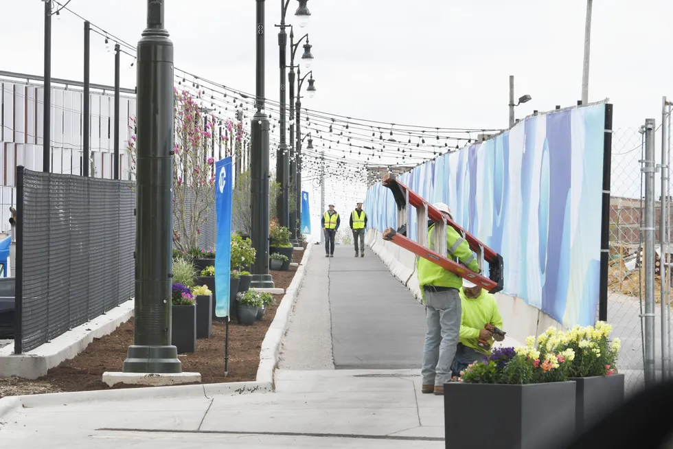 Work finishes up on a walkway from Behind the Book Depository building to Bagley Street in Detroit on Monday.