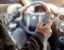 A man using a cellphone while behind the wheel.