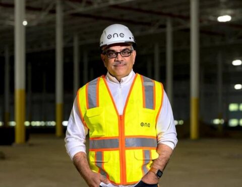 Mujeeb Ijaz posing in a construction vest and hard hat