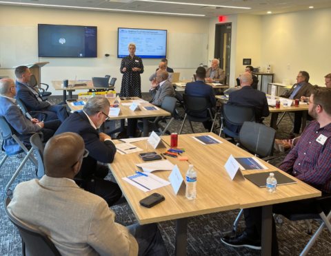 several people sitting, listening to a presentation
