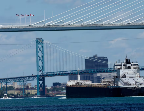 A ship passes the Gordie Howe International Bridge and Ambassador Bridge on June 12. (Jeff Kowalsky/Bloomberg)